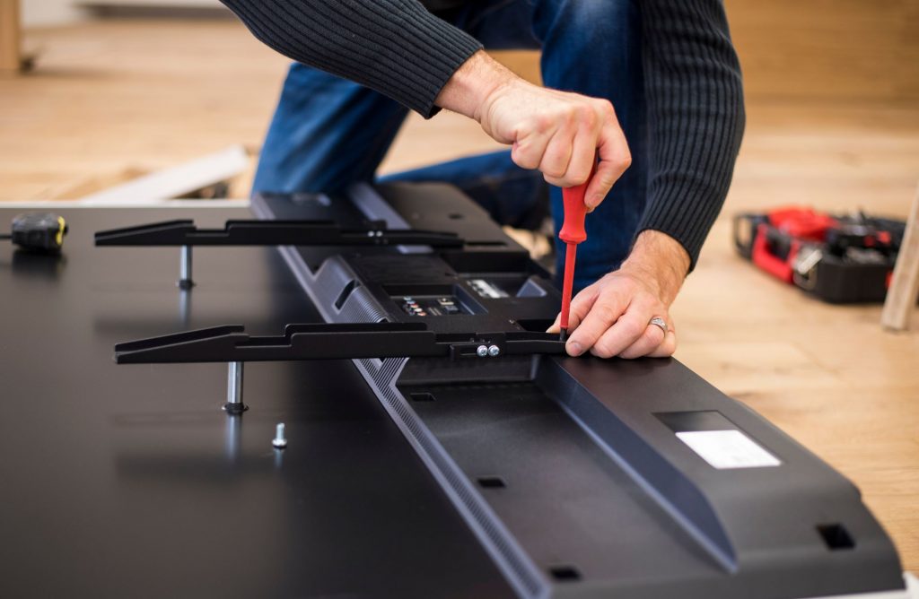Man attaching TV to bracket with the correct VESA compatibility