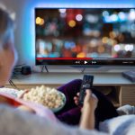 Woman watching TV over HDMI extender signal