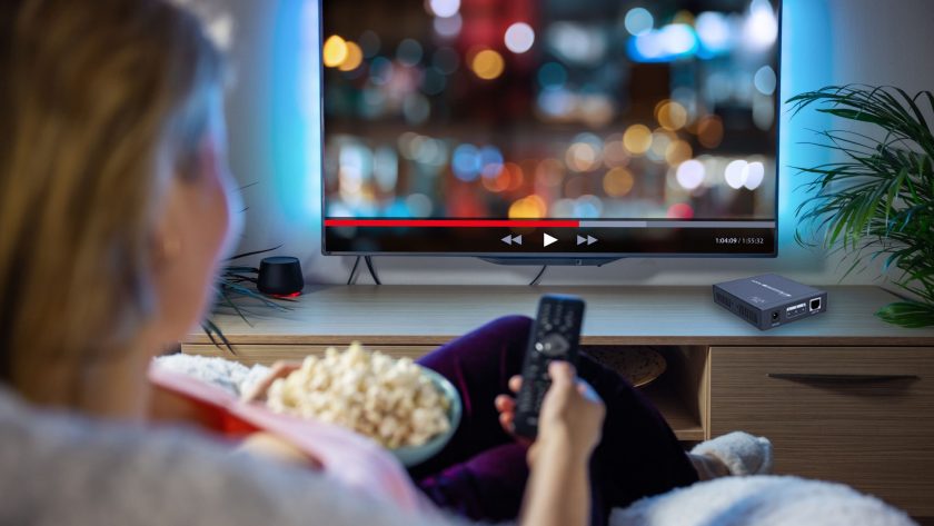 Woman watching TV over HDMI extender signal