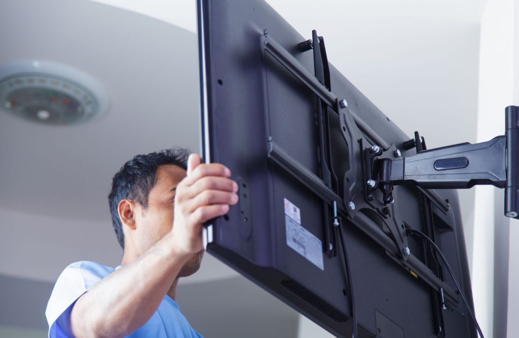 Man installing TV bracket to a solid wall